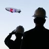 Potential advertisers watch as the M Lightship passes the under-construction M Resort on Wednesday. The blimp will fly for six hours a night, five days a week (unless it's off promoting the M out of state). M owner Anthony Marnell hopes ad sales will help pay for the blimp's lease. 