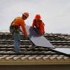 In this file photo, Vivint Solar employees install solar panels on a home.