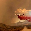 This photo provided by the National Park Service Mojave National Preserve shows a tanker making a fire retardant drop over the York fire in Mojave National Preserve on Saturday, July 29, 2023.