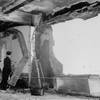 A fireman stands beside a twisted girder as he examines the gaping holes in the north side of the Empire State Building, on the 79th floor, evidence of the terrific impact with which a B-25 Army bomber crashed into the structure in New York, July 28, 1945. 