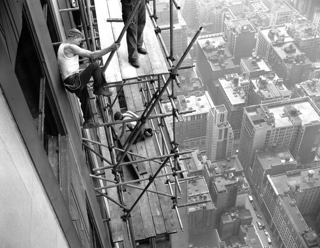 Workmen rig scaffolding on the south side of the 78th floor of the Empire State building, New York, N.Y., July 30, 1945, after an army B-25 bomber crashed into the structure. The bomber, which crashed into the north side of the building, lost one of its motors during the impact causing it to exit through the south side of the skyscraper.  
