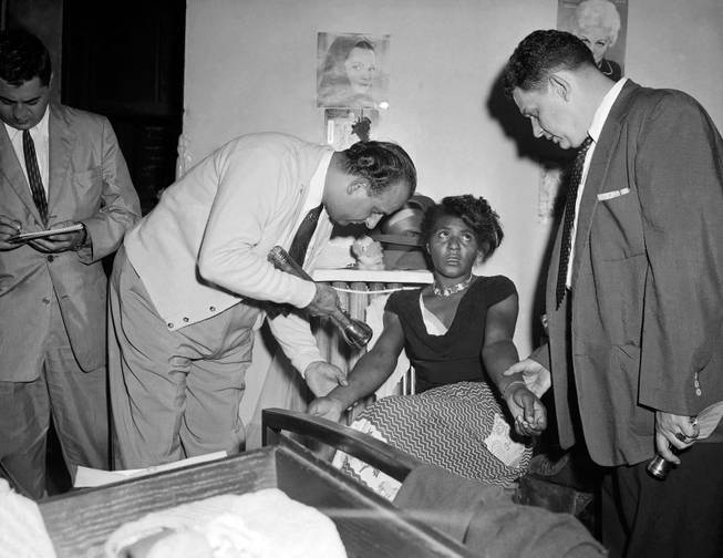 In this Sept. 22, 1957 file photo, police Detectives John Matassa, center and Sheldon Teller, right, examine the arms of a suspected narcotics addict and dealer in New York. Eric Schneider, a professor at the University of Pennsylvania said after World War II, heroin became a drug primarily used by blacks and Puerto Ricans in the Northeast and by Mexican Americans in the West. In the late 1960s, at the height of the hippie drug experimentation era, there was a resurgence of heroin use among young white people in the East Village and in San Franciscos Haight-Ashbury district.