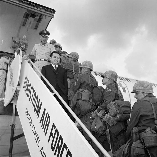 Sen. Daniel Inouye of Hawaii (dark suit) watches troops of the 2nd Armored Division, Fort Hood, Texas board a C135 jet transport plane on Oct. 23, 1963 at Bergstrom Air Force Base, Austin, Texas for a flight to Germany.   The senator, a member of the Senate Armed Services Committee accompanied them on their flight, a part of exercise big lift. Col. Frank R. Walsh, 340th group commander, stationed at Bergstrom AFB stands behind Sen. Inouye. (AP Photo)