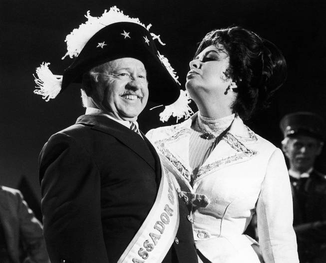 Veteran comic Mickey Rooney is a picture of poise in a Napoleonic era hat as he tapes an I love New York television commercial with British-American actress Elizabeth Taylor on Thursday, August 27, 1981 in New York, United States. Rooney is now starring in the review Sugar Babies on Broadway while Miss Taylor stars in Little Foxes.