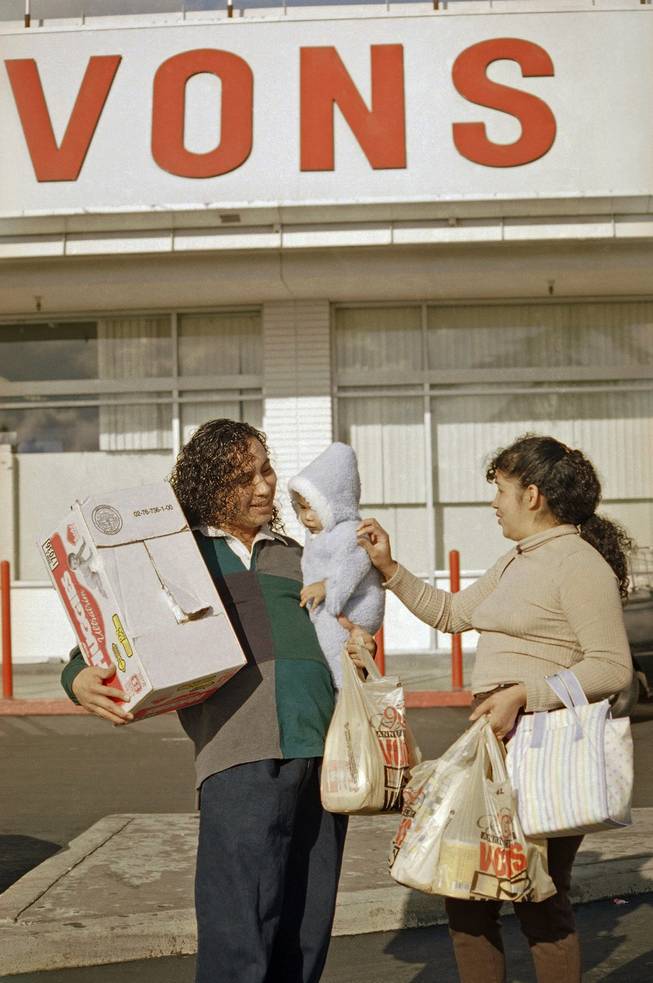 Raul Rios, left, and Rosalinda Ramirez attend to their 5-month-old daughter Angel Mayen, as they leave a Los Angeles Vons grocery store, Oct. 30, 1996. Safeway Inc. proposed a stock-swap merger with the Vons Companies Inc., to create a California grocery giant that would be the second-largest in North America. 