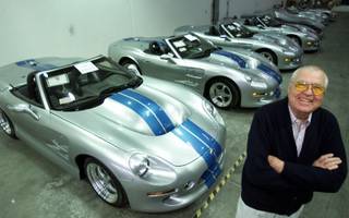 Automotive legend Carroll Shelby poses in front of his Shelby Series 1 sports cars at his plant in Las Vegas, Friday, Oct. 27, 2000. The Texas-born Shelby is mass producing a new generation of roadsters not in Detroit, but in the desert outside Las Vegas. The $174,975 Shelby Series 1 sports cars are 21st-century clones of his 1965 Cobra. And unlike his earlier model, the Shelby Series 1 has creature comforts like roll-up windows and air conditioning.