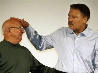 FILE - In this Oct. 9, 2003, file photo, boxing great Muhammad Ali touches the head of his former coach Angelo Dundee at the Book Fair in Frankfurt, Germany. Dundee, the trainer who helped groom Ali and Sugar Ray Leonard into world champions and became one of boxing's most recognizable figures, died Wednesday, Feb. 1, 2012. He was 90. (AP Photo/Michael Probst, File)