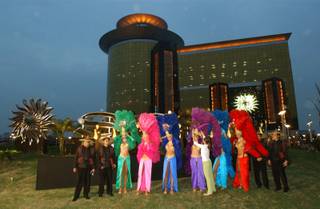 Las Vegas dancing girls adjust their costums as they are joined by employees of the Las Vegas Sands casino dressed as old style Chinese tea traders as they get ready to pose for a picture in front the Las Vegas Sands casino in the former Portuguese enclave of Macau, on Monday, May 17, 2004, one day before it is due to open.