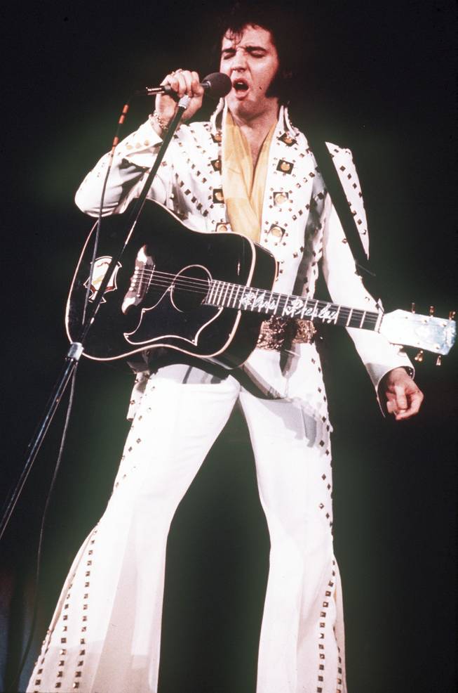 **FILE** Elvis Presley sings during a 1973 concert. Presley fans will soon have a place in the islands to fondly remember why they couldn't help falling in love with the star of "Blue Hawaii."  Wearing his signature flare-legged, big-collared, bejeweled and strategically snug ensemble, the King will reappear in the islands in the form of a life-sized bronze statue marking the site of his historic 1973 concert "Elvis: Aloha From Hawaii." (AP Photo)