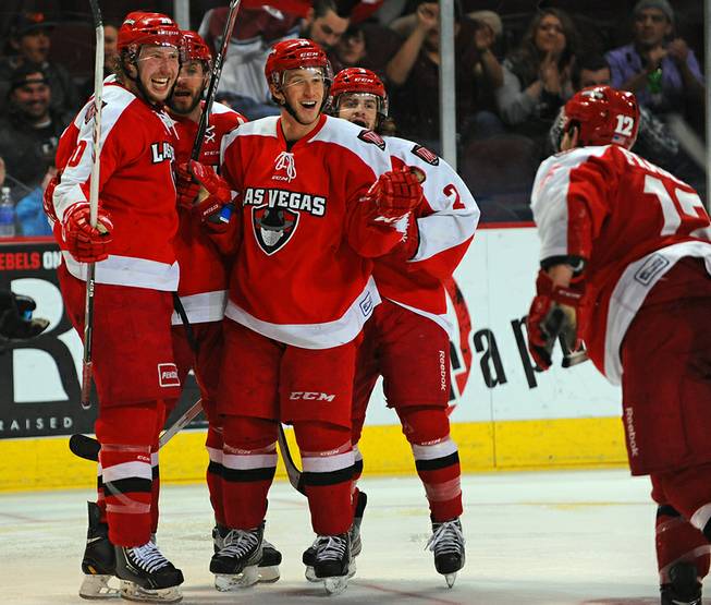 Wranglers Robbie Smith, left, and Adam Hughesman, center, celebrate after Smith scored a game-tying goal in the third period against the Idaho Steelheads on Friday night.