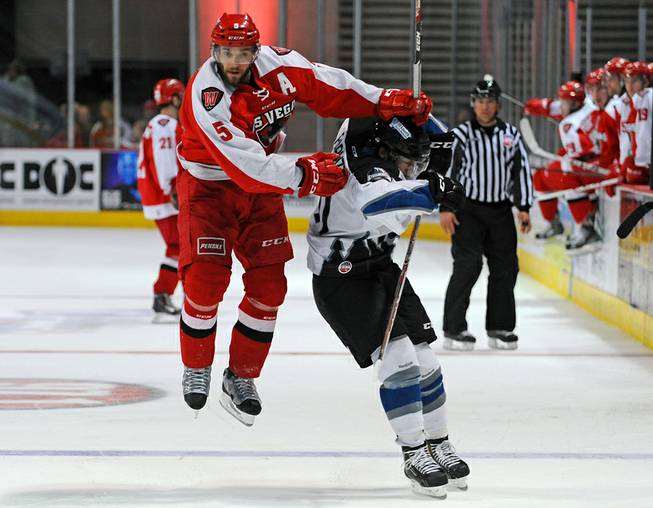 Las Vegas defenseman Charlie Cook (5) leaps around Idaho Steelheads forward William Rapuzzi after shooting the puck into the Idaho zone during the third period of play on Friday night.