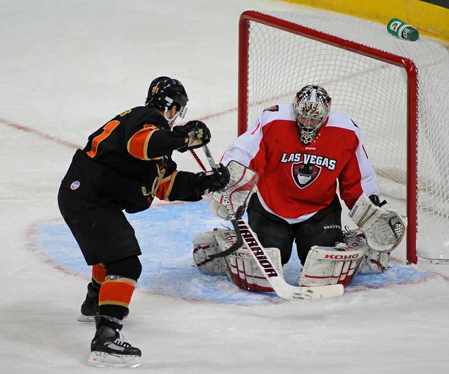 Las Vegas Wranglers goaltender Mitch O'Keefe fights off the puck as San Francisco forward Adrian Foster (21) looks to knock it away during an ECHL game at the Orleans Arena on Sunday afternoon.