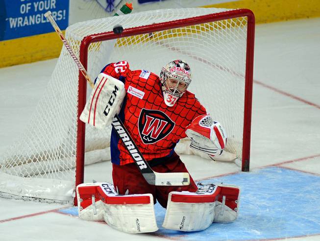Las Vegas Wranglers goaltender Travis Fullerton deflects a rising shot from the Idaho Steelheads during the first period of play on Saturday night.