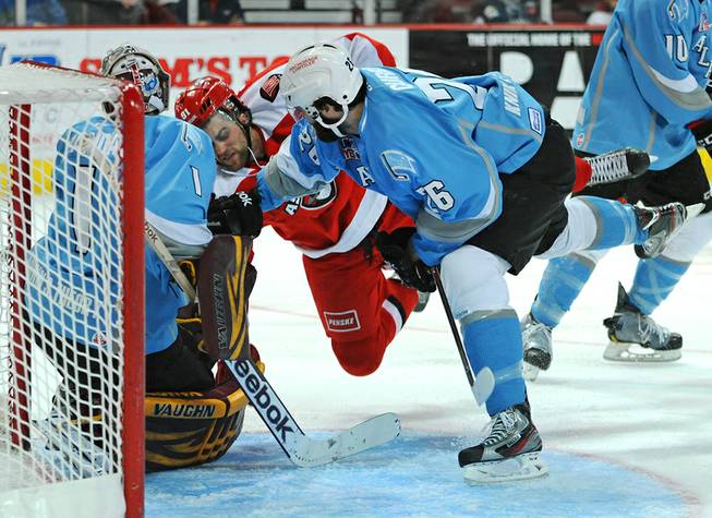 Las Vegas Wranglers center John Armstrong (91) is thrown down in the Aces crease by Alaska defenseman Sean Curry during the third period on Sunday afternoon.