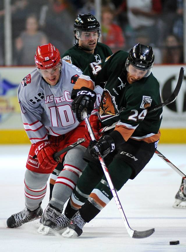 Las Vegas Wranglers captain Geoff Paukovich, left, battles for control of the puck with Utah Grizzlies defenseman Martin Lee during the third period of play on Friday night.