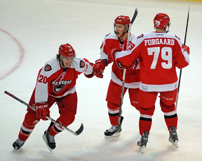 Las Vegas Wranglers forward Adam Hughesman, center, celebrates with Robbie Smith, left, after assisting on a Smith goal against the Colorado Eagles on Tuesday night. At right is Wranglers defenseman Ryan Forgaard.