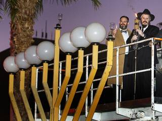 Attorney Jacob Hafter and Rabbi Shea Harlig light the Grand Menorah during a celebration for the first night of Hanukkah at the Fremont Street Experience in downtown Las Vegas Tuesday, December 20, 2011. The event was sponsored by Chabad of Southern Nevada.