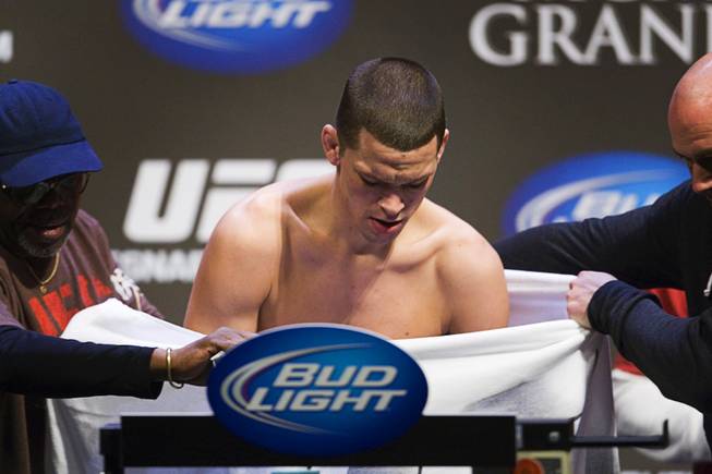 Lightweight fighter Nate Diaz stands on the scale behind a towel after coming in one pound overweight during the UFC 141 weigh-in at the MGM Grand Garden Arena Thursday, Dec. 29, 2011. Diaz came back later and made weight.