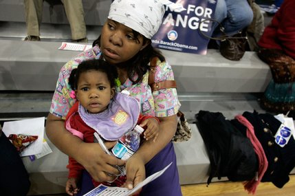 Brandee Coleman, with her 16-month-old daughter, Jalynn, fills out a card for Barack Obama during the caucus at Rancho High School. 