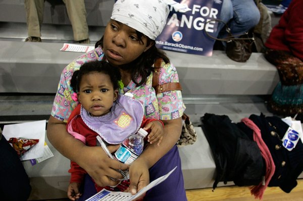 Brandee Coleman, with her 16-month-old daughter, Jalynn, fills out a ...