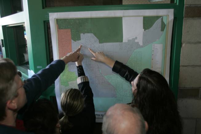 Voters look for their precincts on a map during the Republican presidential caucus at Green Valley High School in Henderson Saturday, January 19, 2008.