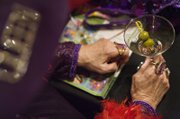 Arlene Gretz, queen of the Desert Bloomers of Henderson Red Hat Society chapter, sips a martini Monday while visiting at Harrah’s with members of four other Clark County chapters of the group for women 50 and older. Las Vegas has more than 150 chapters. Red Hatters wear purple hats instead of red in the month of their birthday.