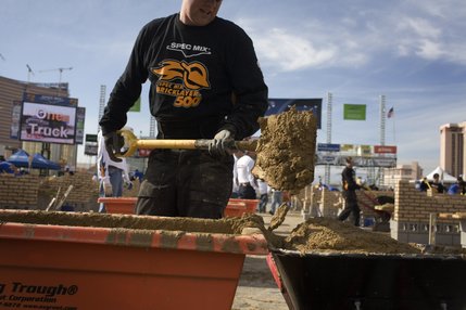 Tender Ken Huisenga refills last year's winner, Mike Boll's, wheel barrow with mortar during the final moments of the Spec Mix Bricklayer Competition at The World of Concrete convention at the Las Vegas Convention Center on Thursday, January 23, 2008.