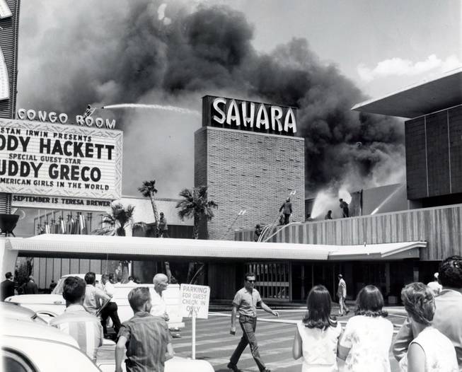 Guests hang back as firefighters work to put out the blaze at the Sahara hotel in 1964. This fire is a precursor to the devastating MGM Grand fire in 1980.