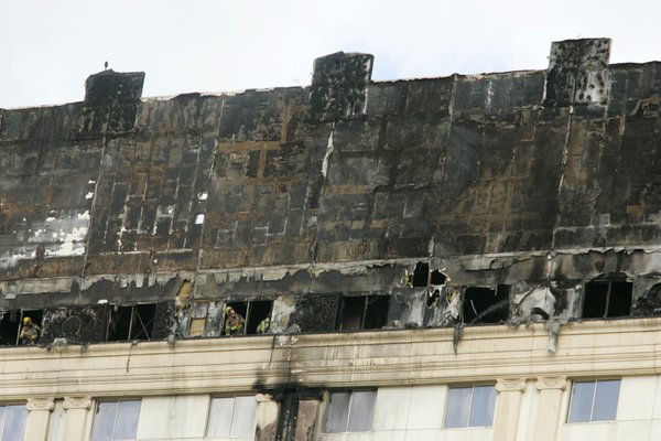 Firemen look out the top floor of the Monte Carlo ...