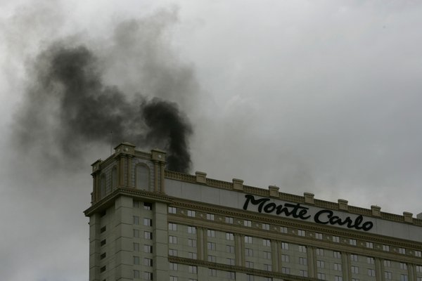 Smoke from a roof fire pours from the top of ...