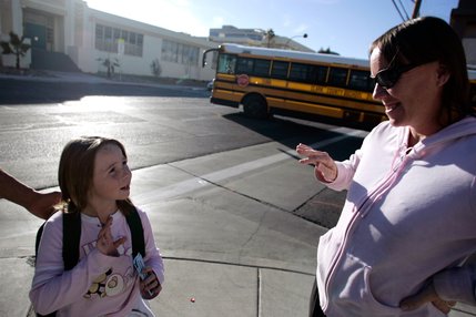 Tricia Velasquez picks up her daughter, Mariah, 7, from a school bus stop in downtown Las Vegas. Hunger and insecurity often make children like Mariah grow sad, angry and unable to focus on their schoolwork. They frequently change schools, making academic progress more difficult.