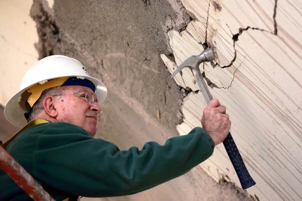 Engineer Mel Green taps the cracks in the concrete on the structure of the old La Concha Motel lobby to test the structure.