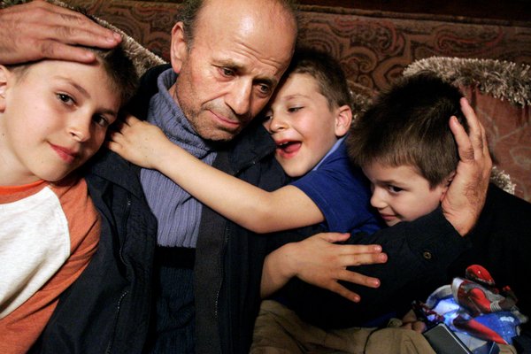 Zyber Selimaj, sits with his sons (from left) Alban, 11, ...
