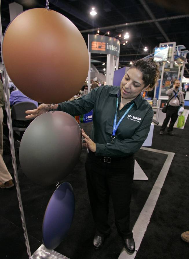 Danielle Robinson shows discs with BASF Corp.’s color-shifting “vari-cool” roof coatings at the International Roofing Expo.