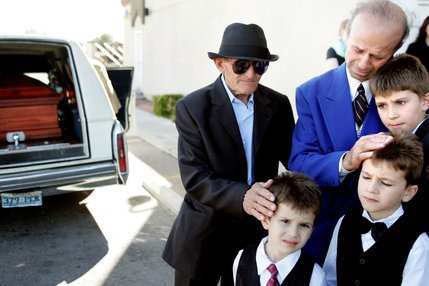 Clockwise from top right, Zyber Selimaj his children Alban, 11, Azbi, 7, and Arber 5, and their grandfather Sherif Luzi stand near the vehicle carrying the coffin of wife, mother and daughter Deshira Selimaj. 