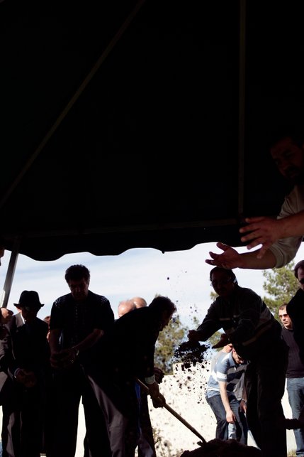 Handsfull of earth are thrown into the grave during the burial for Deshira Selimaj at the Bunker's Eden Vale Cemetery in Las Vegas