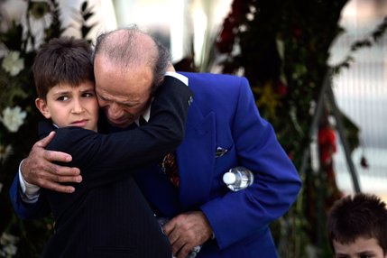 Alban Selimaj hugs his father Zyber during the burial for his mother Deshira Selimaj at the Bunker's Eden Vale Cemetery. 