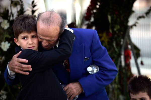 Alban Selimaj hugs his father Zyber during the burial for ...