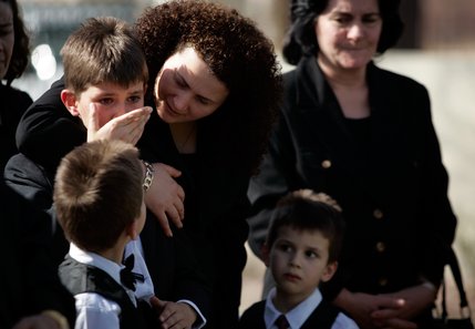 As the grave for Deshira Selimaj is filled, her sons Azbi, 7, Alban, 11, and Arber, 5, are comforted by their aunt Majola Luzi. 