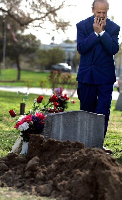 Zyber Selimaj stands over the grave of his wife Deshira just after it had been covered with earth. 