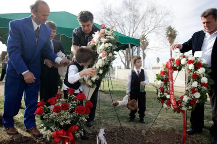 Azbi Selimaj, 7, kisses a photo of his mother that was placed on her grave at Bunker's Eden Vale Cemetery.