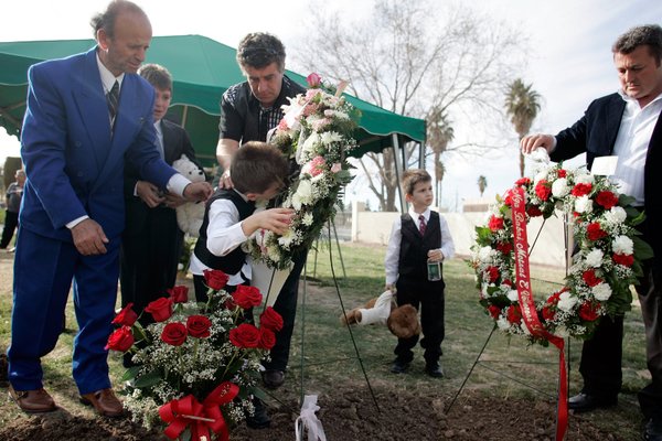 Azbi Selimaj, 7, kisses a photo of his mother that ...