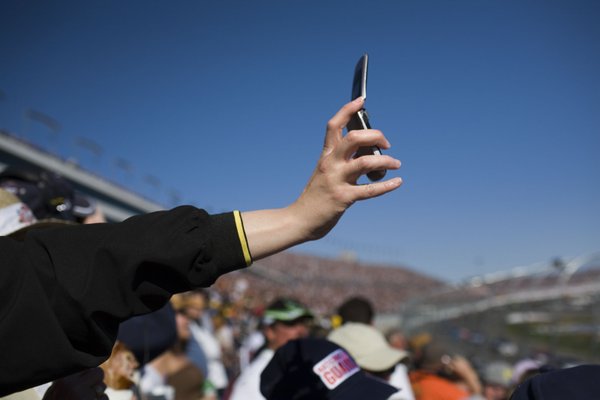 Tricia Delay, of Las Vegas, holds up her cell phone ...