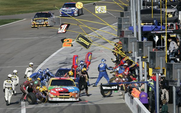 Kyle Busch, foreground, and Kurt Busch get their cars serviced ...