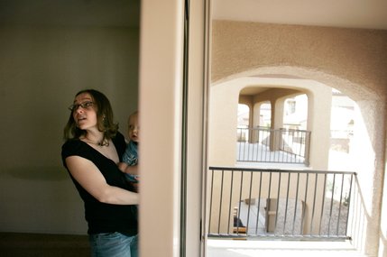 Michelle Haid and her son Wyatt, 1, walk through one of the homes on the tour. Most have dropped in price by tens or even hundreds of thousands of dollars since the local market peaked in 2006, but many experts expect home prices to continue to fall.