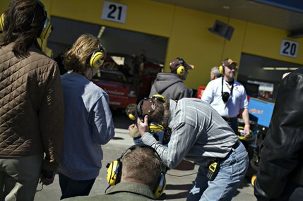 Spectators check out the Neon Garage area before NASCAR UAW-Dodge 400 auto race at Las Vegas Motor Speedway. Headphones allow the fans to listen to race broadcasts or driver team chatter. 