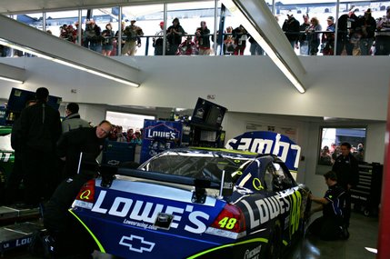 Spectators look in on Jimmie Johnson's Lowe's Racing car in the Neon Garage before NASCAR UAW-Dodge 400 auto race at Las Vegas Motor Speedway.
