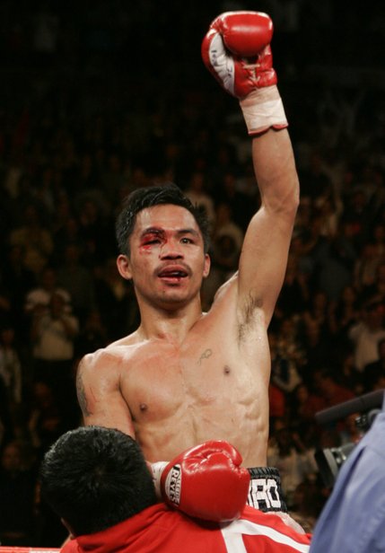 Manny Pacquiao celebrates after going 12 rounds with WBC super featherweight champion Juan Manuel Marquez.