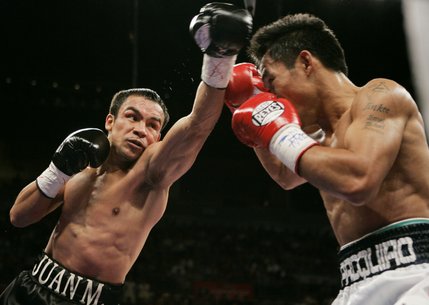 WBC super featherweight champion Juan Manuel Marquez, left, fails to connect on a hook shot during his split-decision loss to Manny Pacquiao.