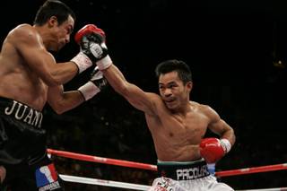 Manny Pacquiao, right, throws a punch at WBC super featherweight champion Juan Manuel Marquez during their title fight Saturday at the Mandalay Bay Events Center in Las Vegas.